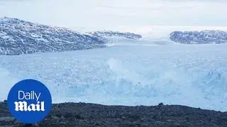 Huge iceberg drifts close to a village on Greenland's coast