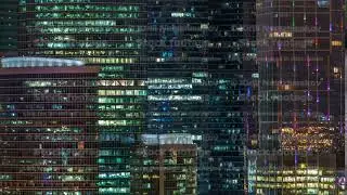 Modern office building with glowing windows at night timelapse. Moscow city