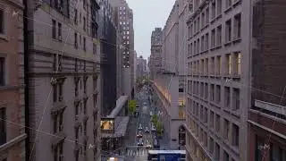 Twilight streetscape revealing Midtown Manhattan buildings, streaming traffic, and iconic