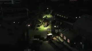 A class 47 pulling Pullman cars past a maintenance depot at night