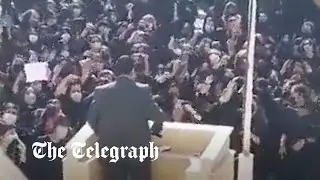Iranian schoolgirls shake headscarves and heckle paramilitary speaker