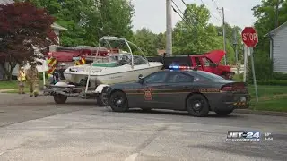 One person extracted from vehicle after car and truck carrying boat collide