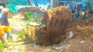Digging the ground to install a large pipe near the fence of a villager's house..