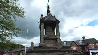 The impressive 17th century Lymm Cross & stocks on sandstone rock in town centre Cheshire England