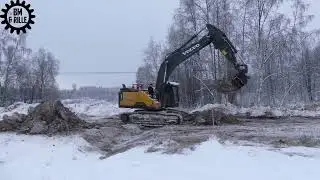 Volvo EC300EL uncover vegetation , loads it on a Scania truck