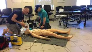 Paramedic demonstrates treatment of adult choking (complete foreign body airway obstruction)