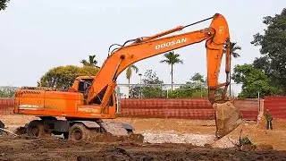 Doosan excavators, wheel loaders, road rollers, and dump trucks are in operation.