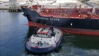 Massive tanker being dock by small tug boat II Magnolia state