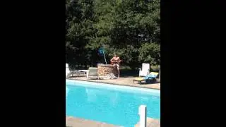 Joe Cox playing guitar by pool in south france