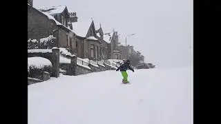 SNOcoat rider Keira snowboarding down the street in Kilsyth