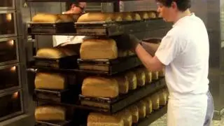 Vers gebakken brood uit vorm halen bij Bakker Van den bogaert Princenhage