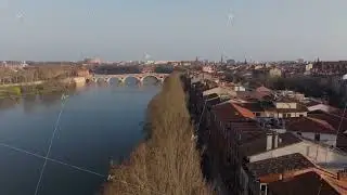 Aerial view of Garonne river and Pont Neuf bridge flowing through Toulouse city center, in Occitanie
