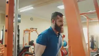 the guy is engaged in a gym on the exercise machine lift heavy