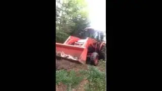 Kubota L4740 hauling a trailer full of wood.