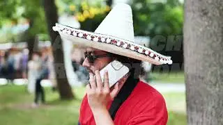 Moscow, Russia - July 5, 2025: Mexican man wearing sombrero and sunglasses talking on smartphone in