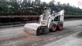 Minicargadora con complemento barredora