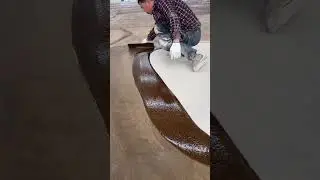 A worker spreads liquid epoxy coating smoothly across concrete floor surface #construction #popular