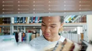 Slow motion of pretty mixed race woman looking through books in library smiling