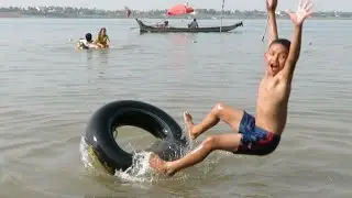 Cambodian Boy Balance Himself on Car Tube