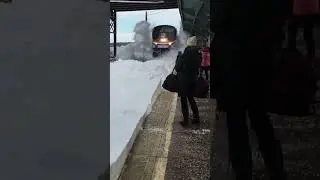 Train Splashes Snow on Bystanders