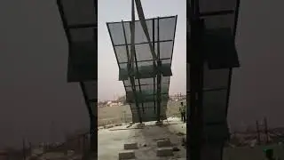 Safety screen net being hoisted by tower crane 