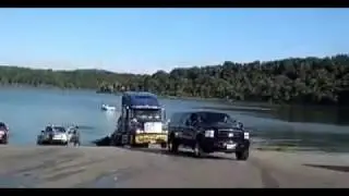 American pickup truck pulls big truck.  Pickup truck flips