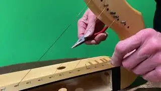 Fitting a wire string through the front of the harp
