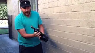 Opening a wine bottle against a wall