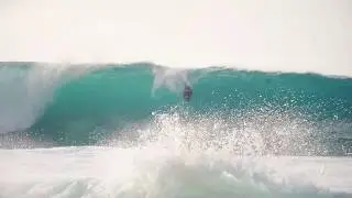Bodyboarder dropping in big wave at Pipeline
