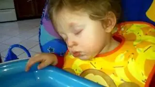 Aaden falling asleep in a high chair.
