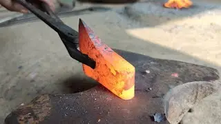 A blacksmith makes an axe from a rusty truck leaf spring.