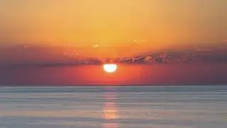 Sunrise over calm sea timelapse hyperlapse. Dawn over horizon, ocean, water. Sun rises over beach