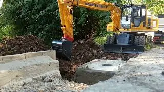 Fumotec Komatsu PW 180-11 beim Kanal schacht  verf&uuml;llen