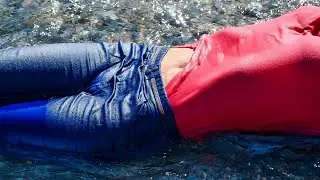 WETLOOK CHIC: BEAUTIFUL GIRL IN WET CLOTHES BATHES IN THE RAYS OF THE SUN AND SEA, POSE, AND RELAXES