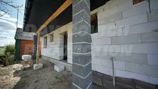 Builders constructing walls of aerated concrete blocks in slavic village