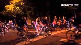 A rolling bicycle party rides through the night Wednesday in Denver.