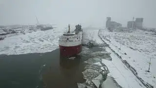 U.S. Coast Guard and tug boat break CSL Frontenac out of its berth in the frozen Welland Canal
