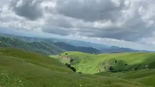 Rolling Green Hills Under Cloudy Sky | Natural Landscape Scenery