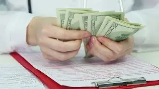 Closeup of doctor's hands counting dollars, corrupt health care system, bribery. Stock Footage
