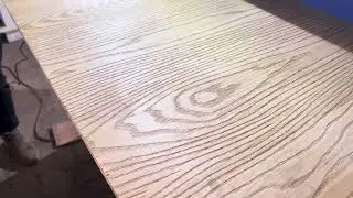 The embossing machine presses the red oak pattern on the pine board.