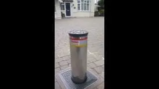 Using an automatic rising bollard for a driveway via a handheld remote control.