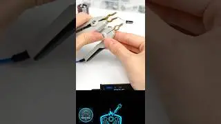 The video displays a person using a component tester equipped with tweezer-style probes to measure