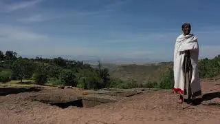 4K Aerial view of a priest in  Saint George, Amhara, Lalibela, Ethiopia