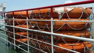 Old orange color small rigid lifeboat or life raft for emergency evacuation in event of disaster