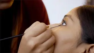 Makeup artist applying eyeliner on the eyes of a young lady us... | Indian Stock Footage | Knot9