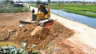 Activity expert bulldozer working push stone landfill with dump truck unloading stone flooded Area.
