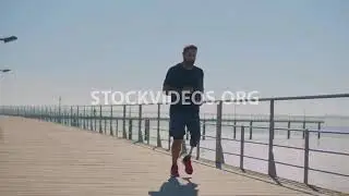 man with prosthetic leg jogging along pu...