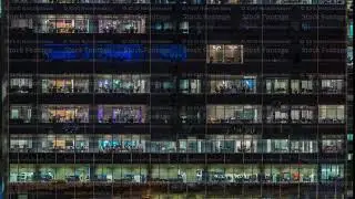 Modern office building with big windows at night timelapse, in windows light shines