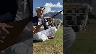 Sultan Ghani baba plying sitar in shandoor polo ground chitrali cultural dress