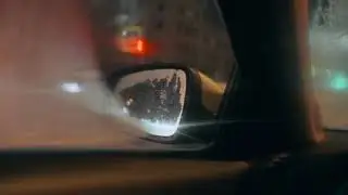 City Traffic at Night through Car's Side View Mirror Stock Footage | Royalty Free